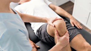 Physiotherapist performing knee therapy on a male patient